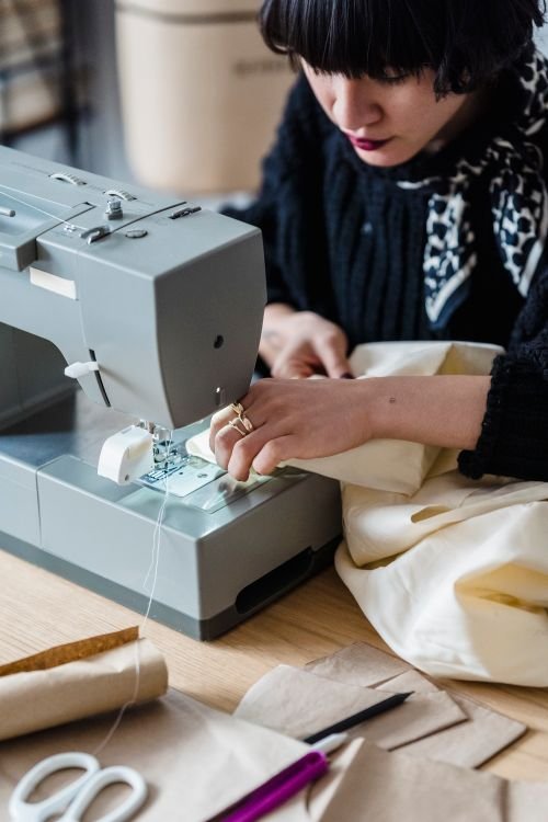 Dressmaker sewing fabric at a sewing machine